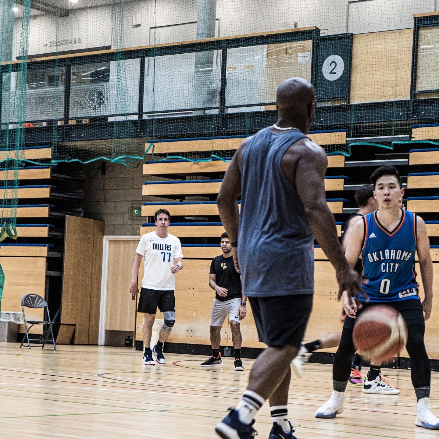 Players running a basketball game on an indoor court