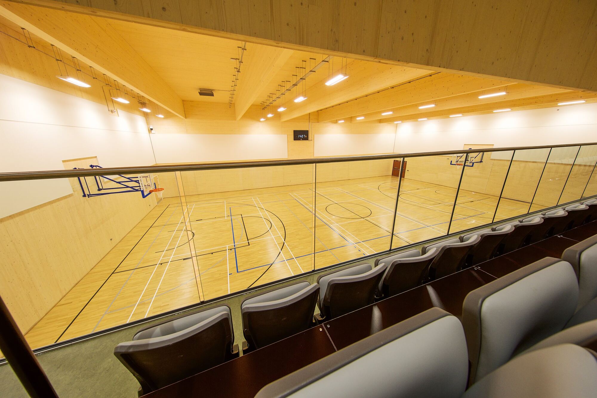 Indoor sports hall with court markings and spectator seating